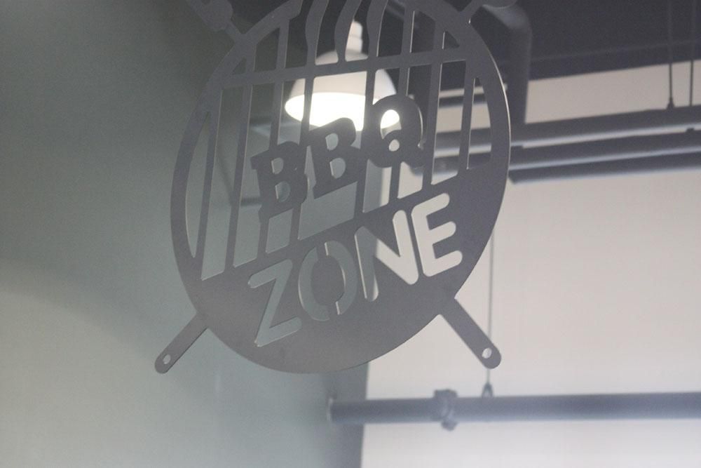 A circular, dark metal sign reading