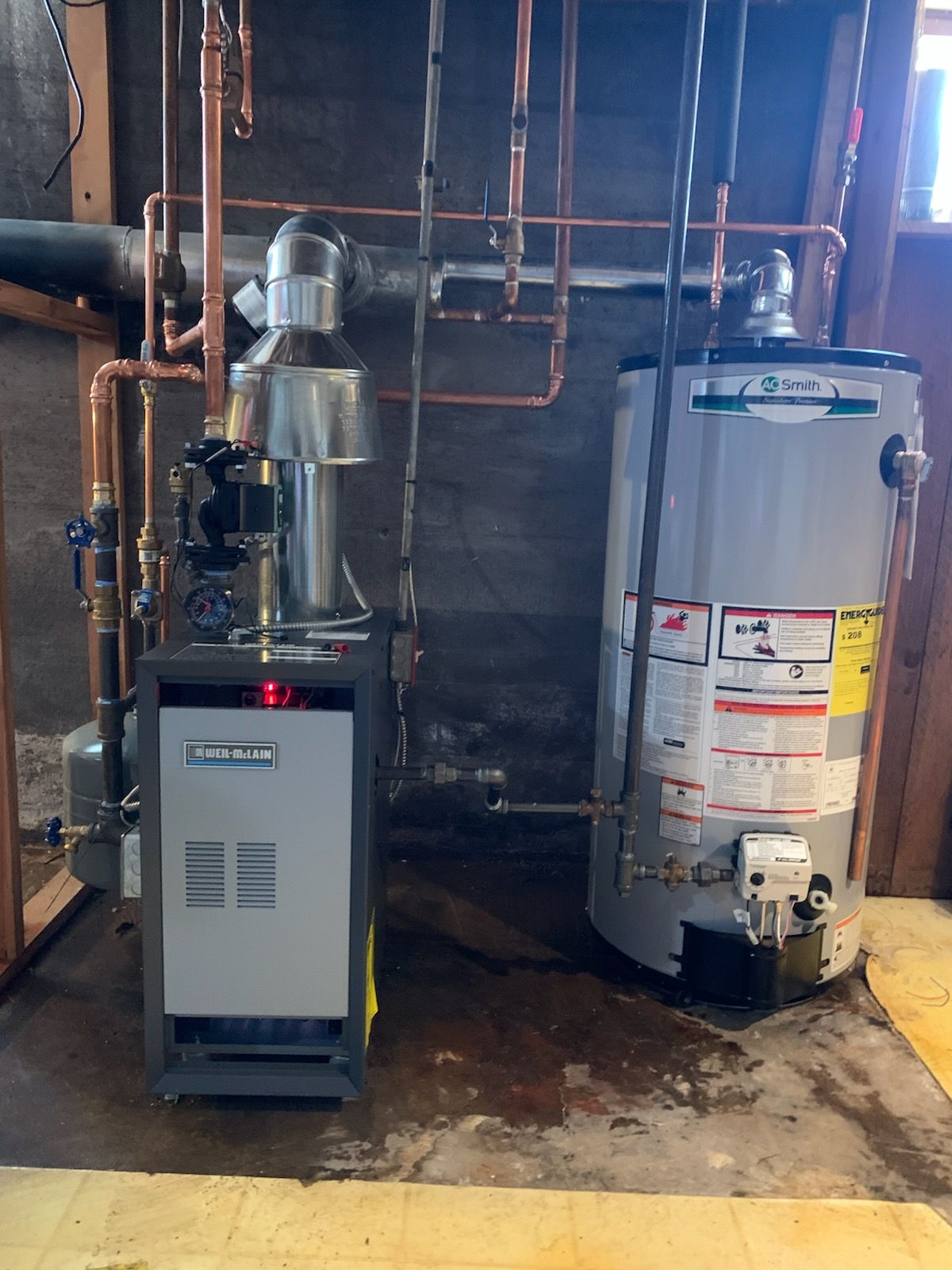Basement utility room with furnace, water heater, and exposed copper pipes.
