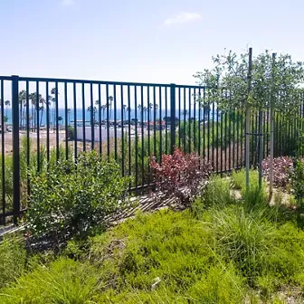 Exterior of a building with large windows, a door, and a dark bench in front.