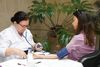 Un profesional sanitario con bata blanca mide la presión arterial de un paciente con un brazalete.
