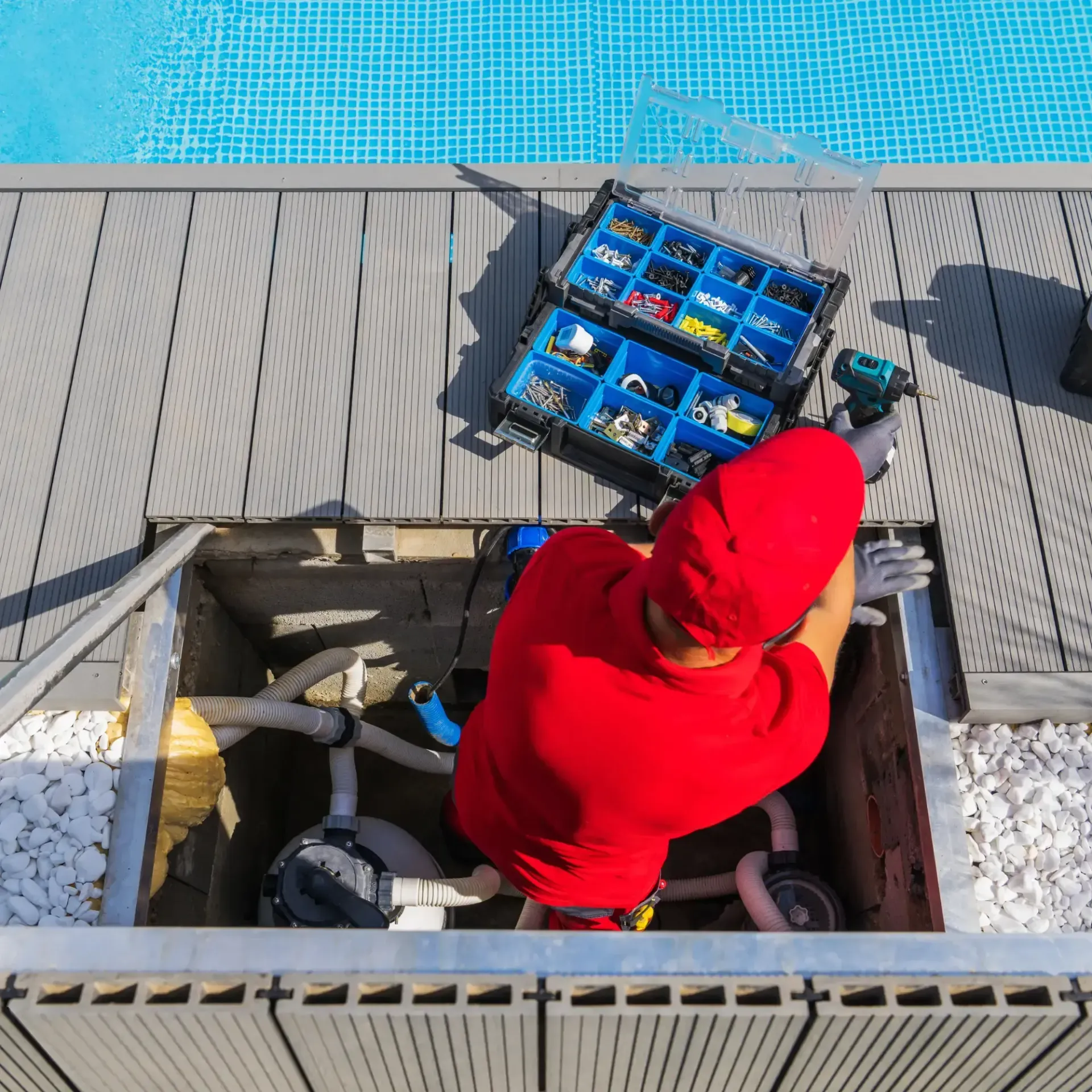H20 Leak Solution- A man in a red shirt is working on a swimming pool.