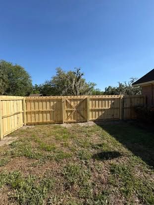 Brick patio with potted plants, stone steps, and a wooden fence beside a house garden Brick patio with potted plants, stone steps, and a wooden fence beside a house garden