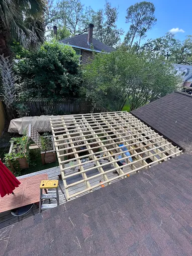 Covered wooden patio overlooking a lush garden with benches and dappled sunlight through a lattice roof Covered wooden patio overlooking a lush garden with benches and dappled sunlight through a lattice roof