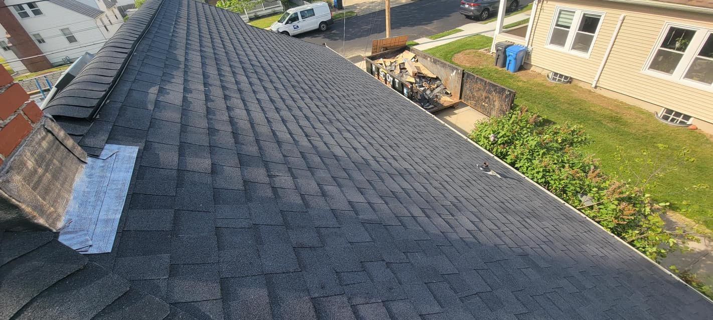 Roof shingles installed on a residential home, viewed from above, showing the completed roofing surf