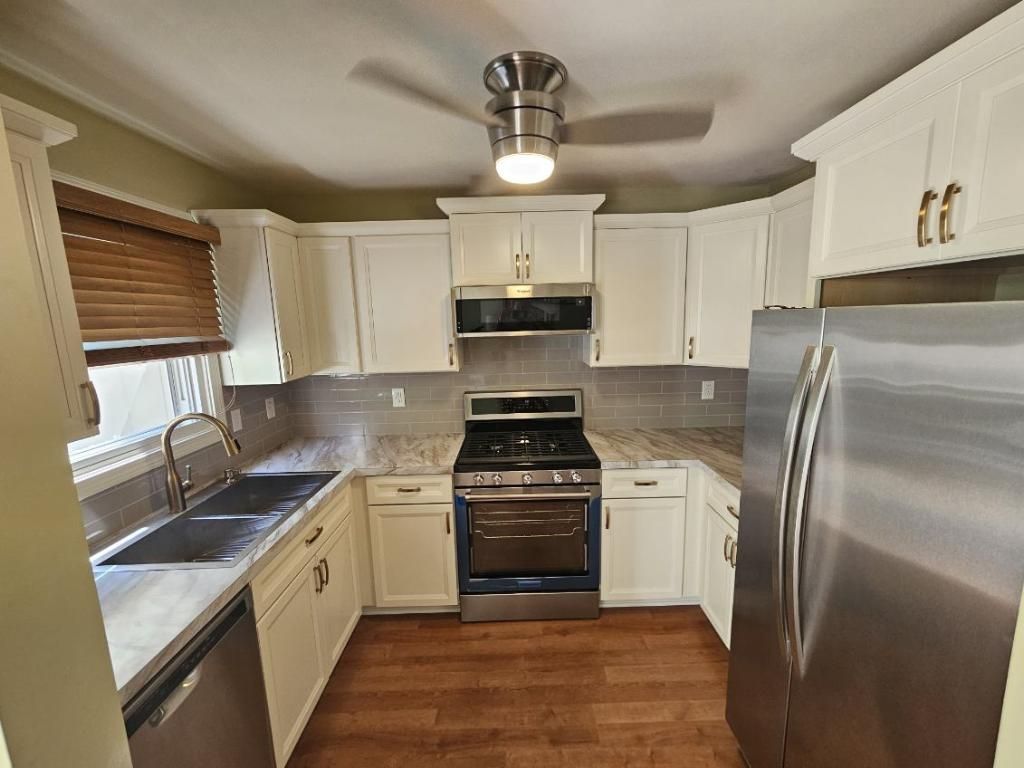 A kitchen with stainless steel appliances and white cabinets