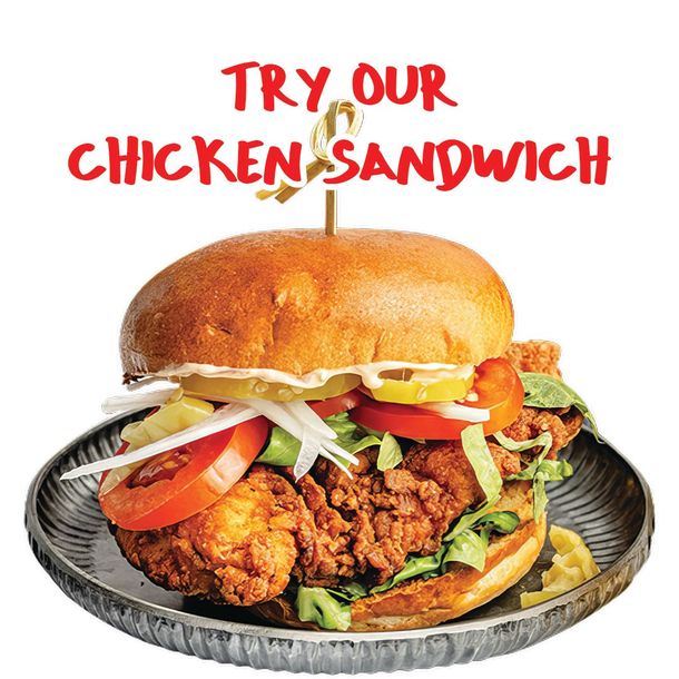 Chicken sandwich on a plate with tomatoes and onions, topped with red text: “TRY OUR CHICKEN SANDWICH”