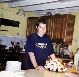 Charlie Gooding standing in a kitchen in front of a worktop and cupboards