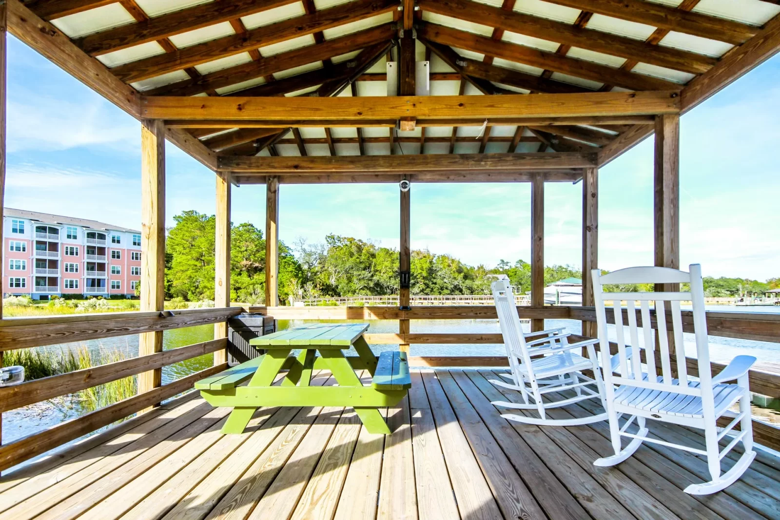 There is a picnic table and rocking chairs on the deck at Sweetwater Apartments.