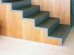Eine Nahaufnahme einer Treppe mit einer Holzwand dahinter.