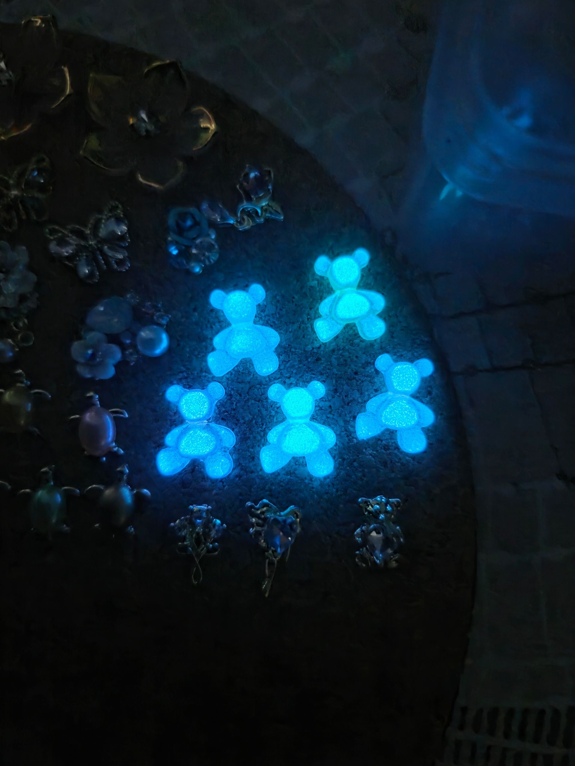 Turquoise oorknopjes met teddybeermotief op een wit, gestructureerd kaartje.
