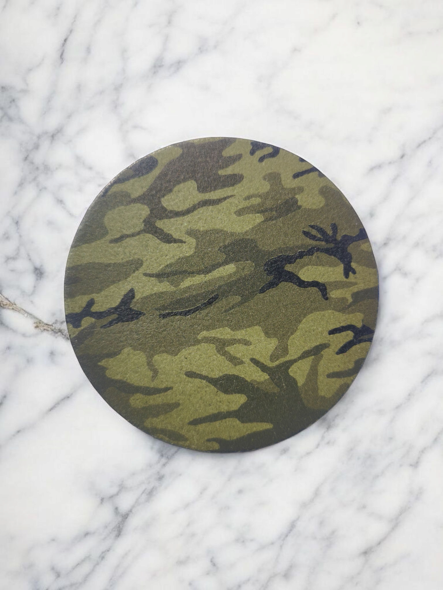 onderzetter camouflagepatroon op een witte marmeren achtergrond.