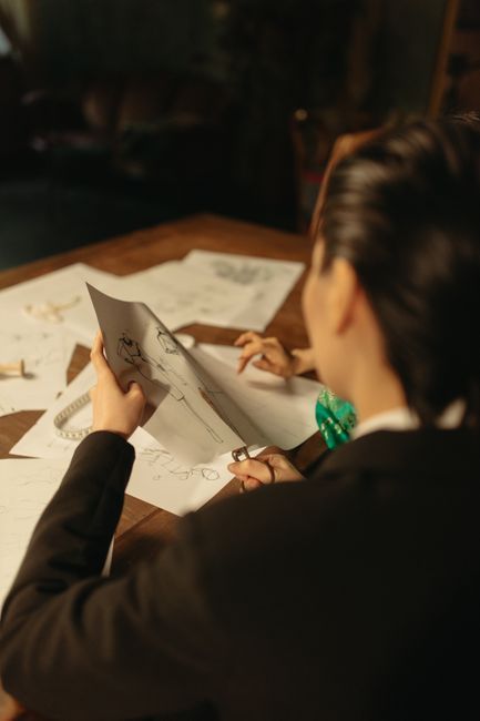 Two people reviewing printed drawings at a table in warm indoor light