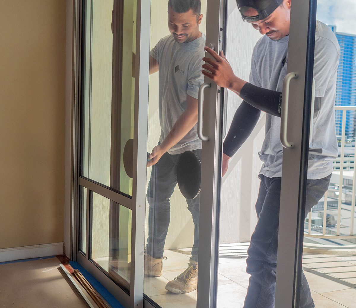Two men are opening a sliding glass door