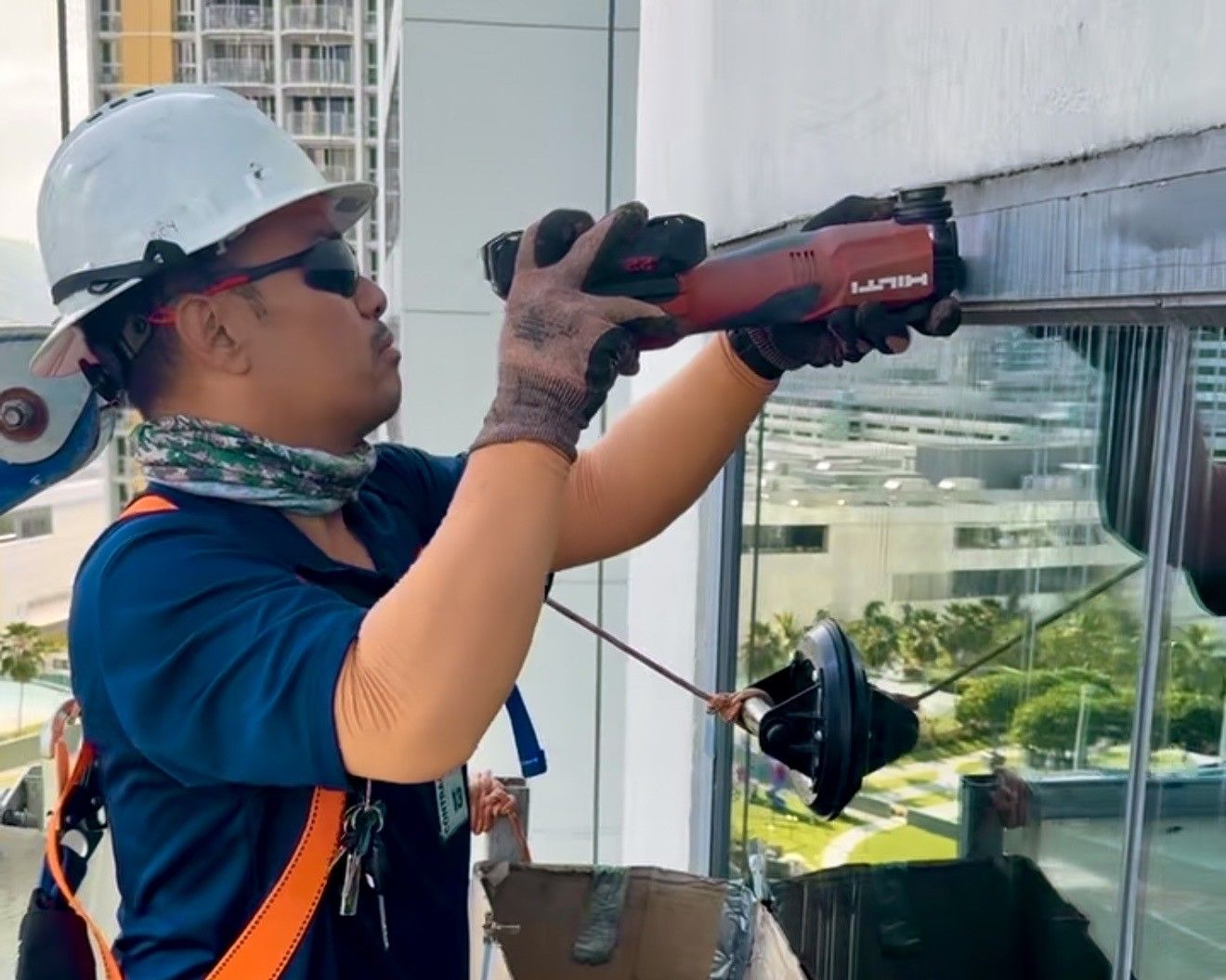 A man wearing a hard hat is working on a building