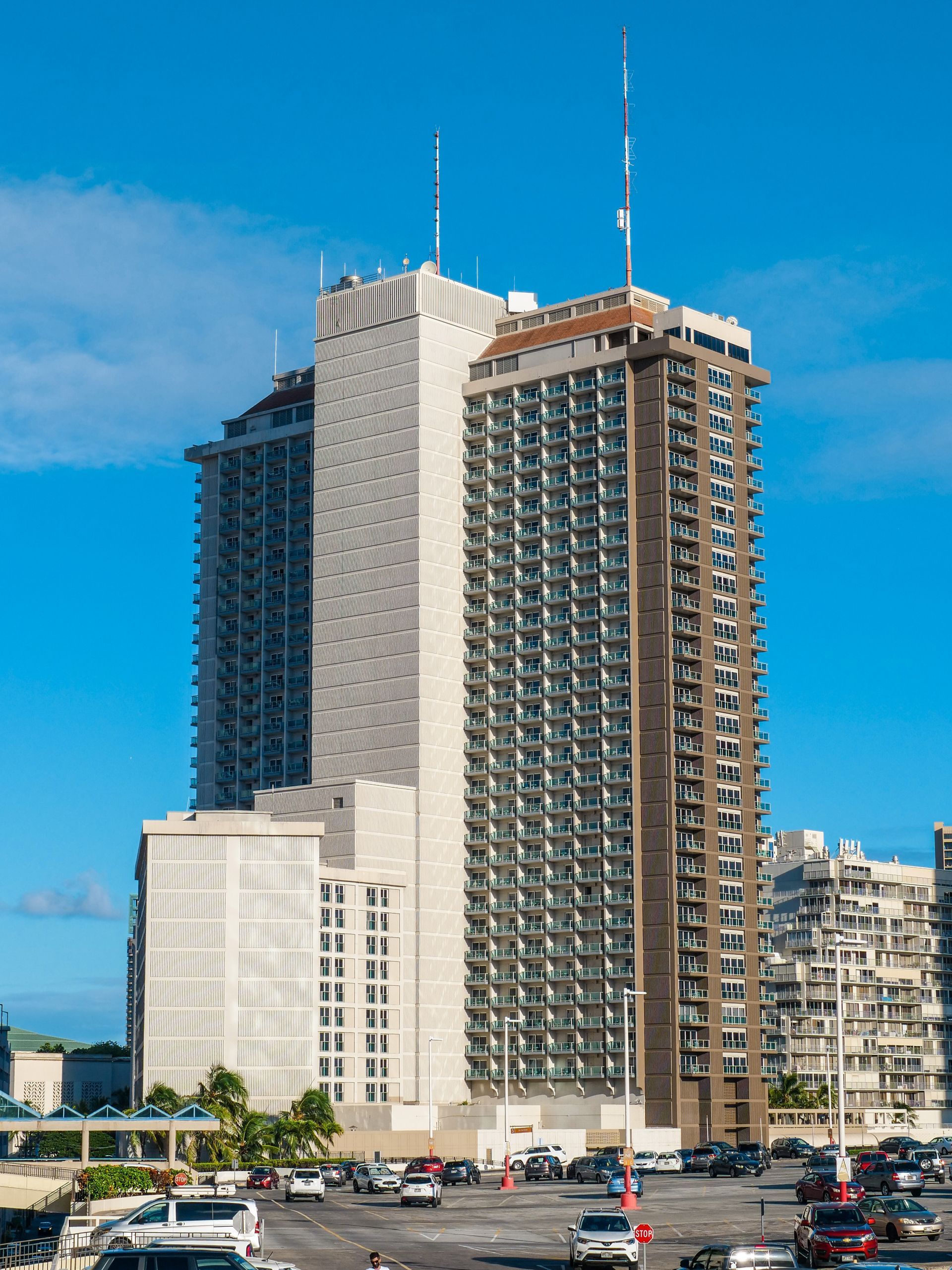 A tall building with a lot of windows is in the middle of a city.