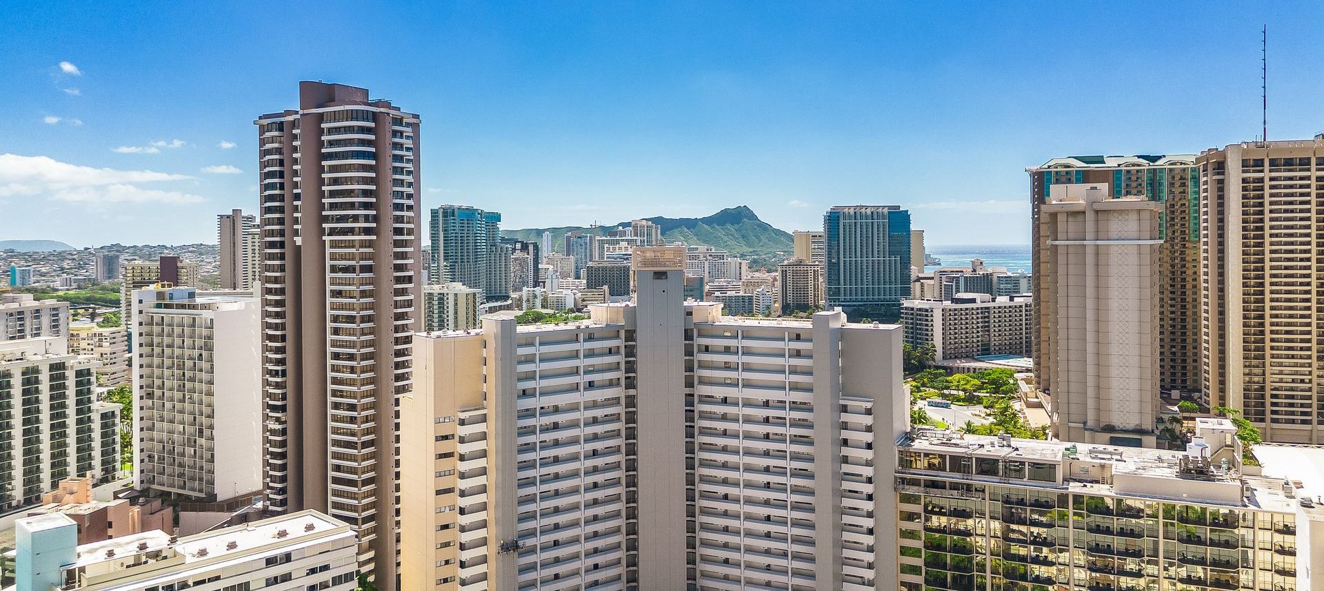 City skyline with tall apartment towers and high-rises under a clear blue sky