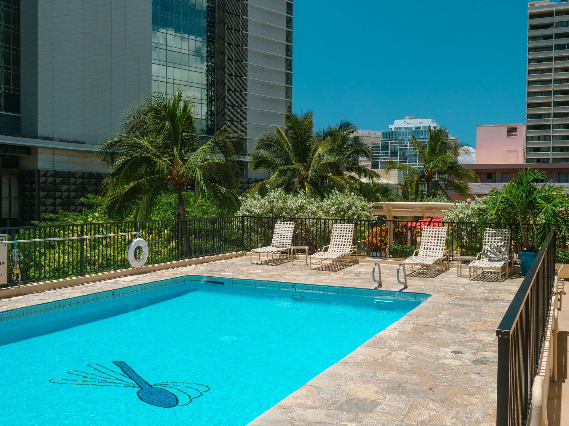 New anodized aluminum guardrails surround the pool deck at the Four Paddle condominium in Honolulu after railing replacement