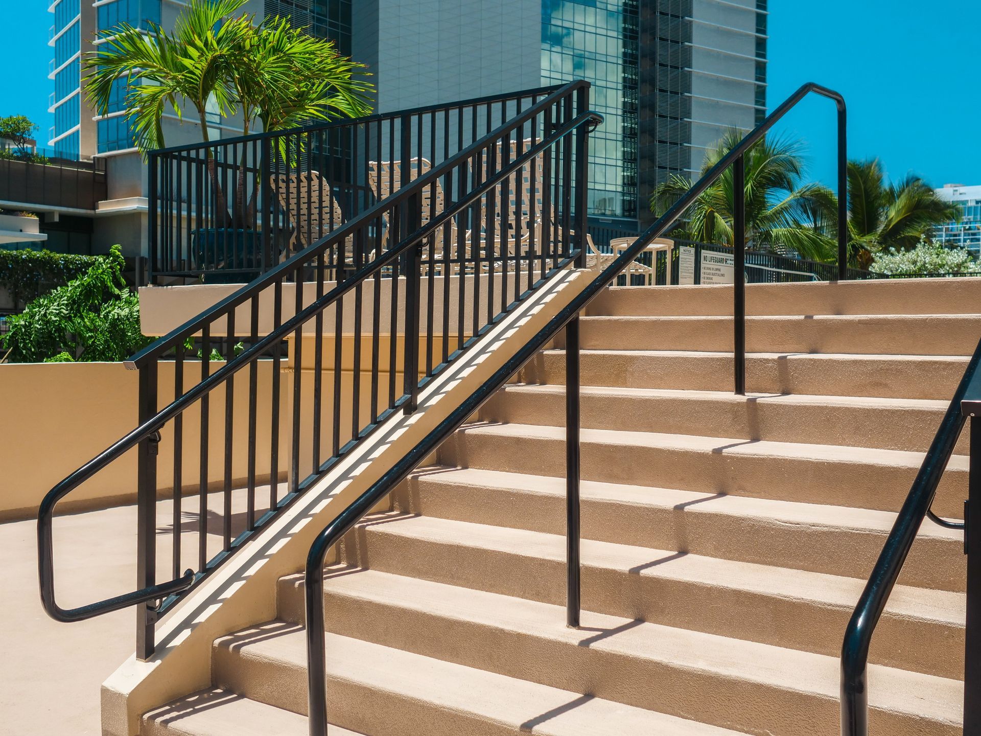 New anodized aluminum guardrail with painted stainless steel handrail on the same pool stairs after replacement