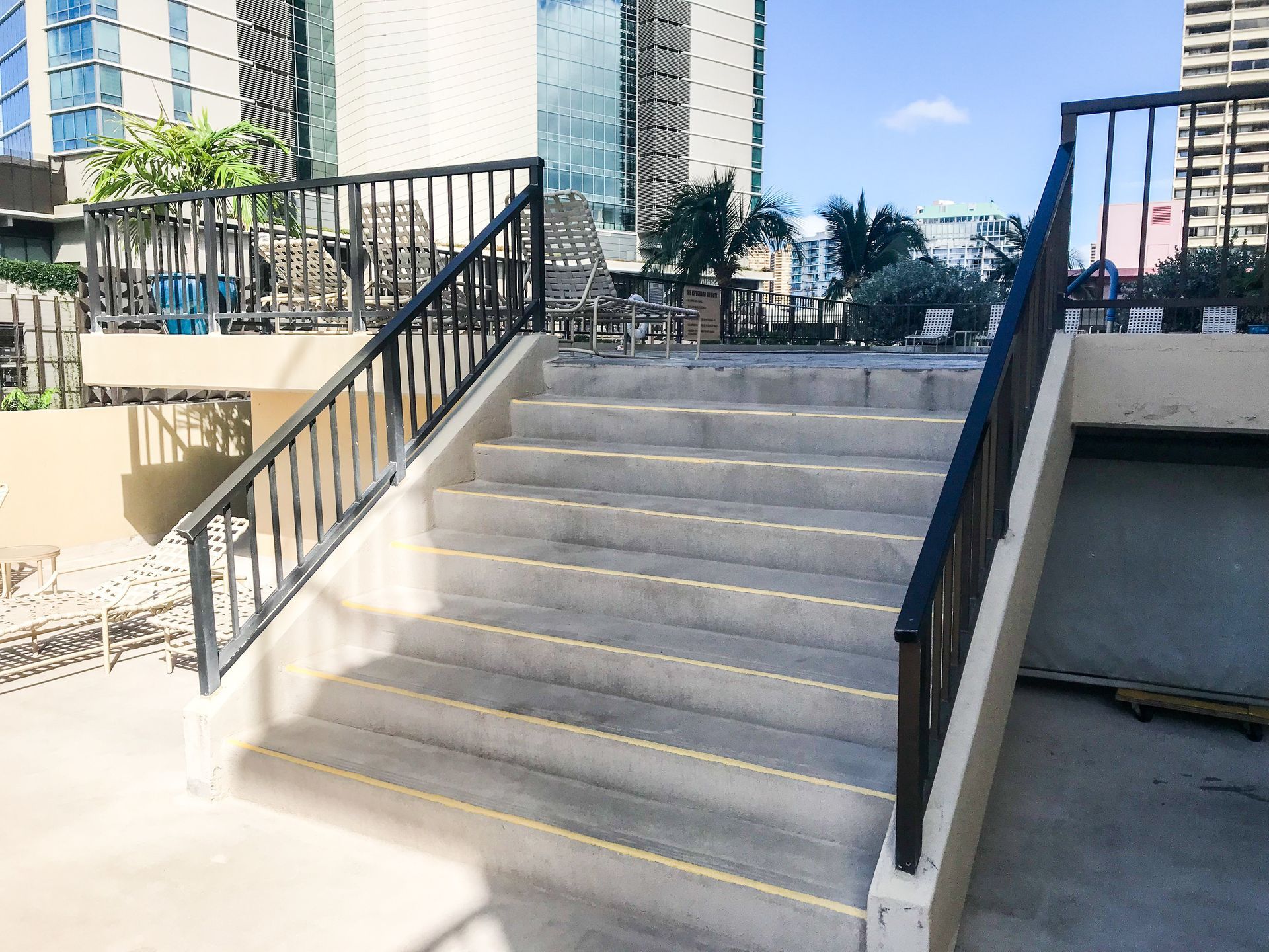 Corroded painted steel guardrail and handrail on concrete pool stairs before replacement