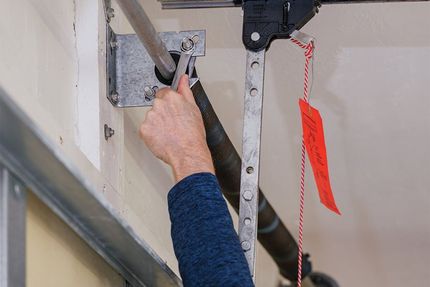 An Uplift Garage technician making garage door repairs and maintenance.