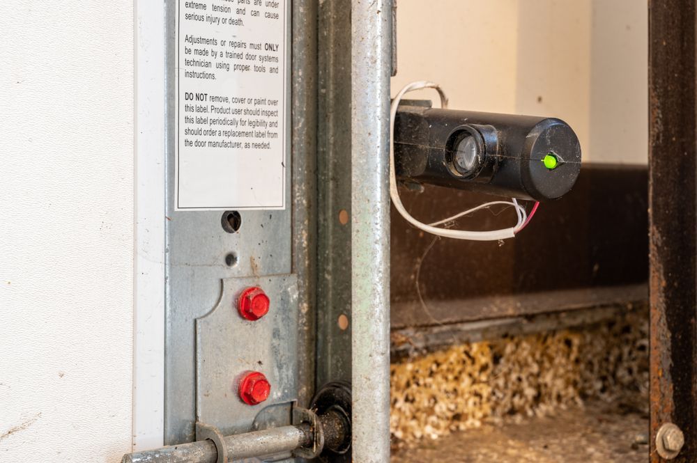 A close up of a garage door with a green light on it.
