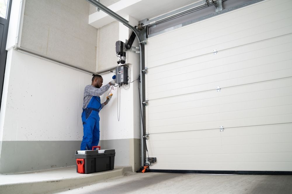 A man installing a wall-mounted garage door opener.