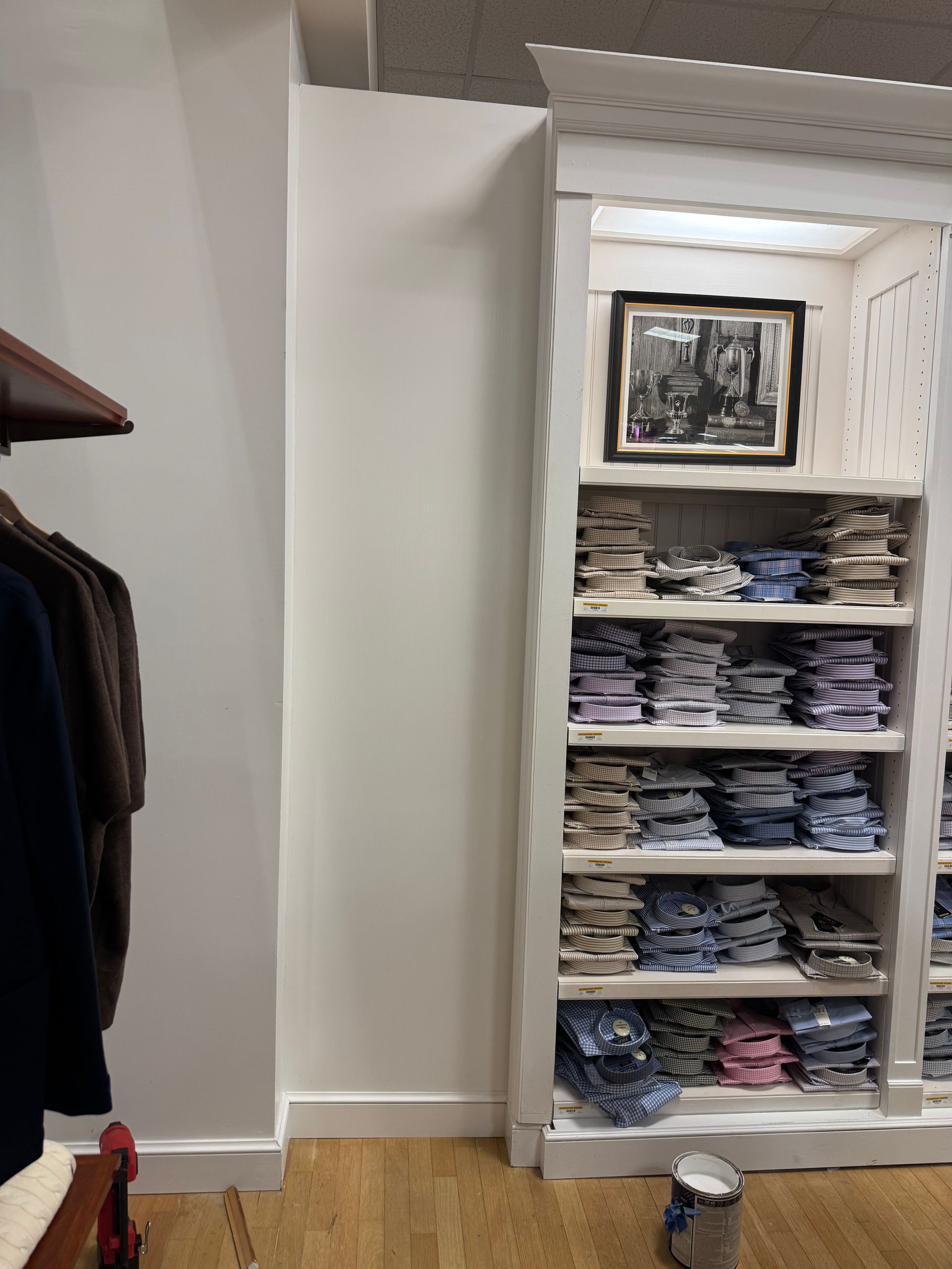 Walk-in closet with dark shelving, wood corner shelves, and built-in lighting