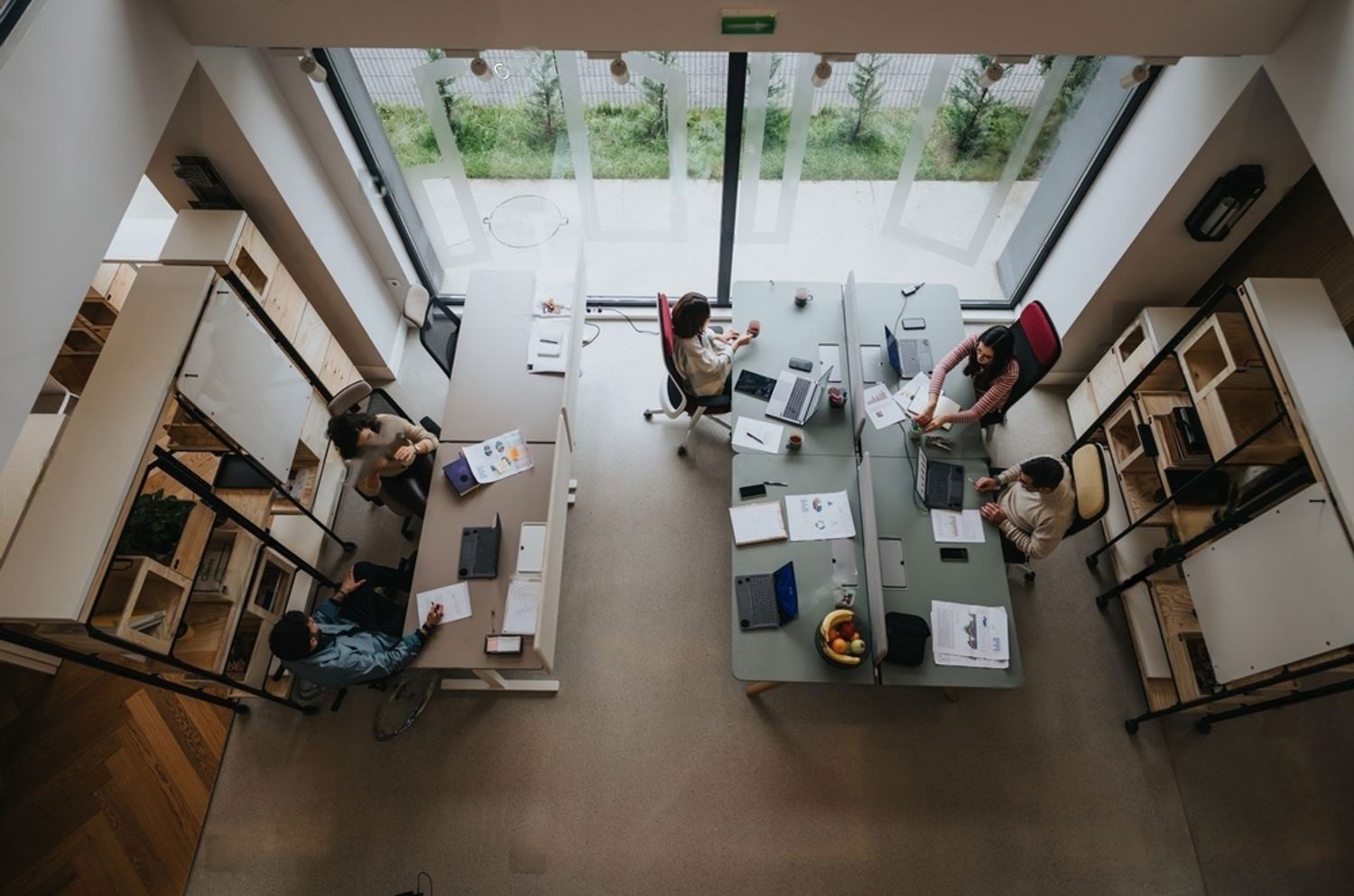 A group of people are sitting at desks in an office.