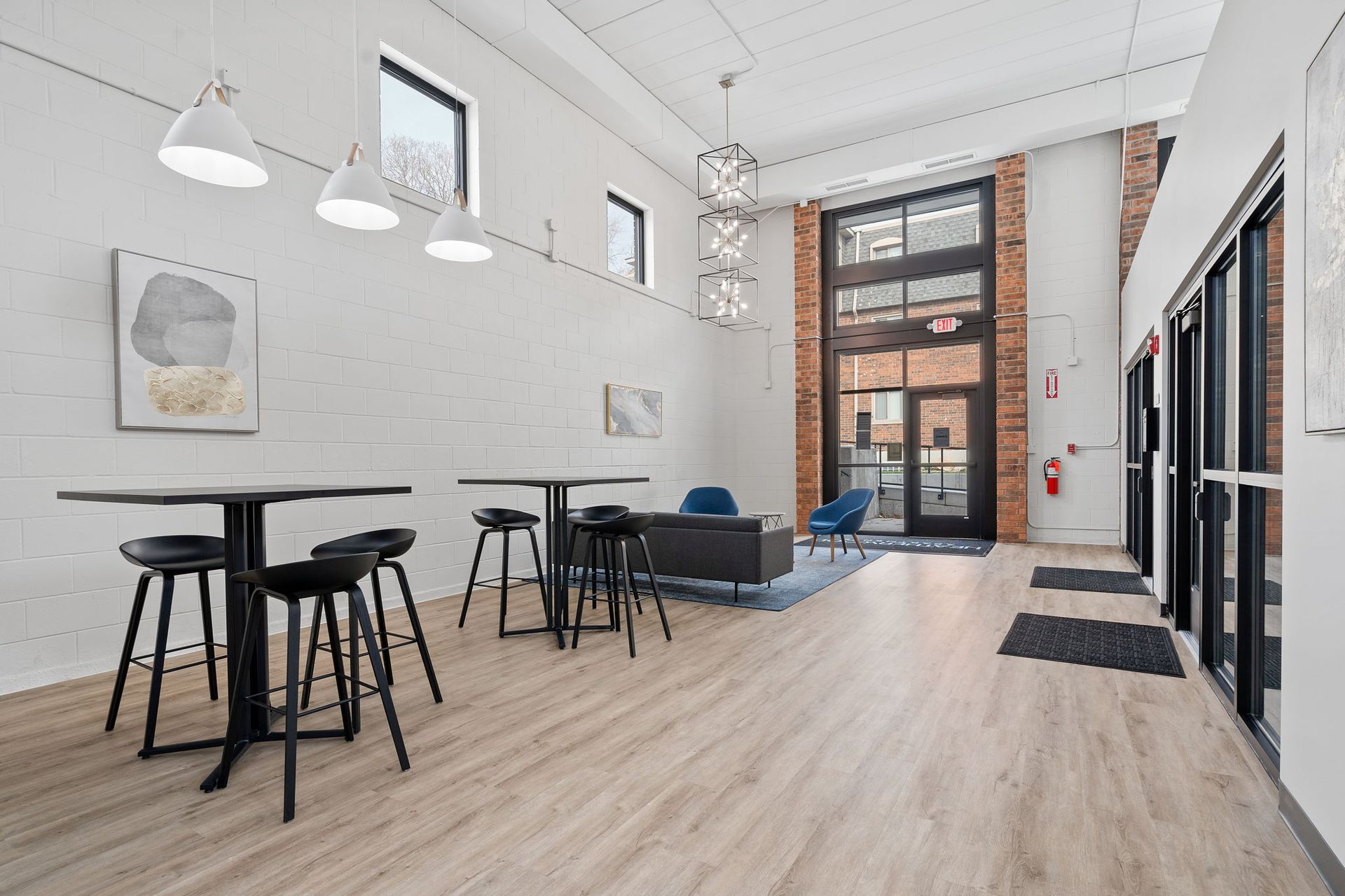 A large room with tables and stools in it.