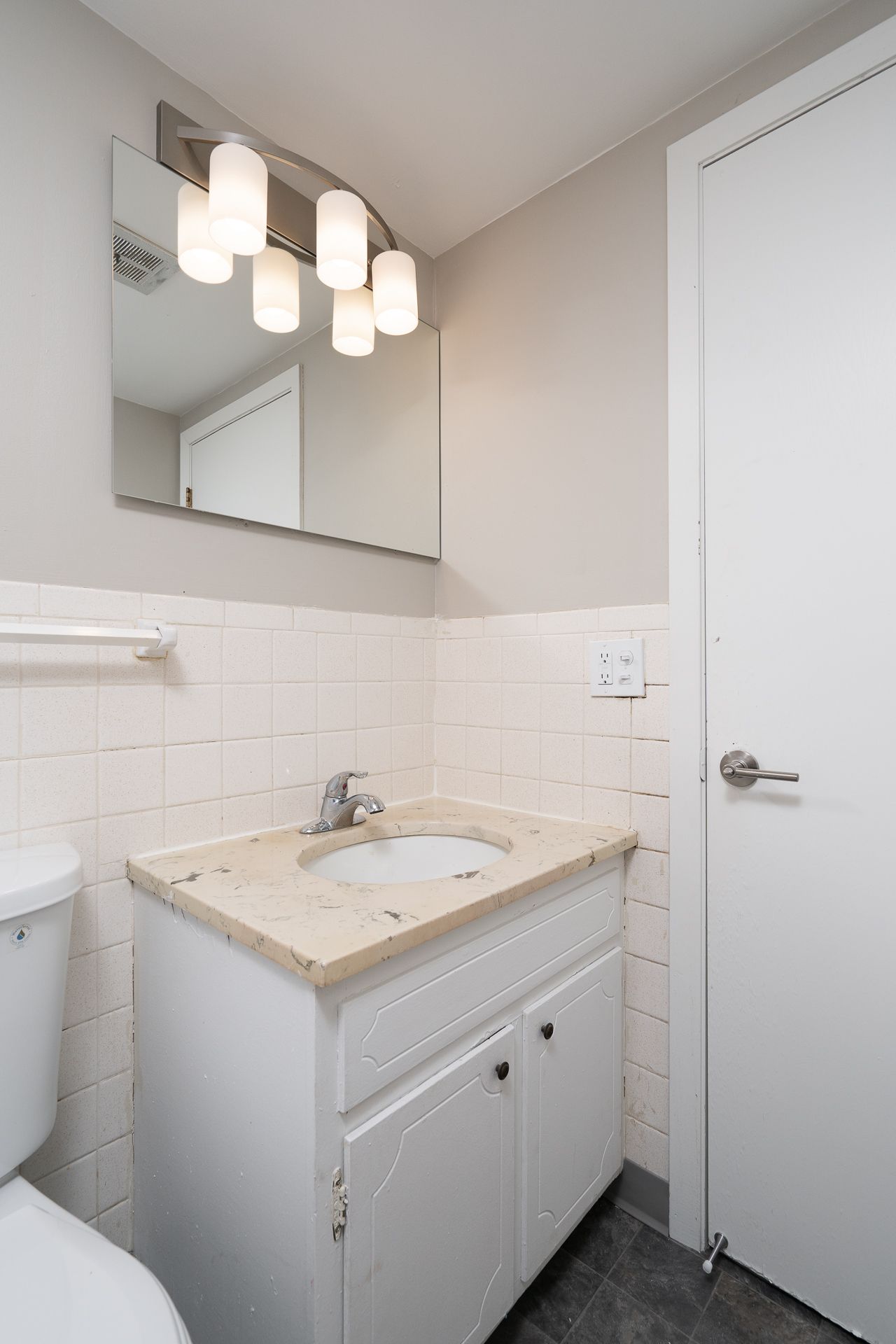 A bathroom with a sink , toilet and mirror.