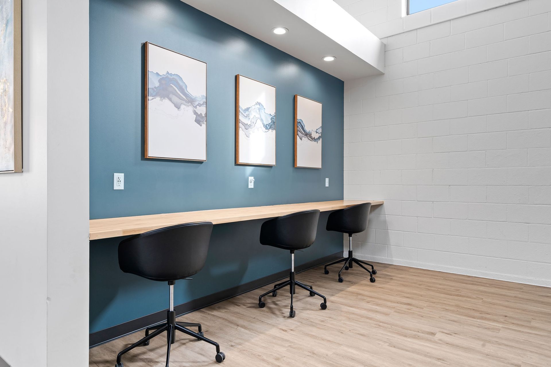 A room with three desks and three chairs in it.
