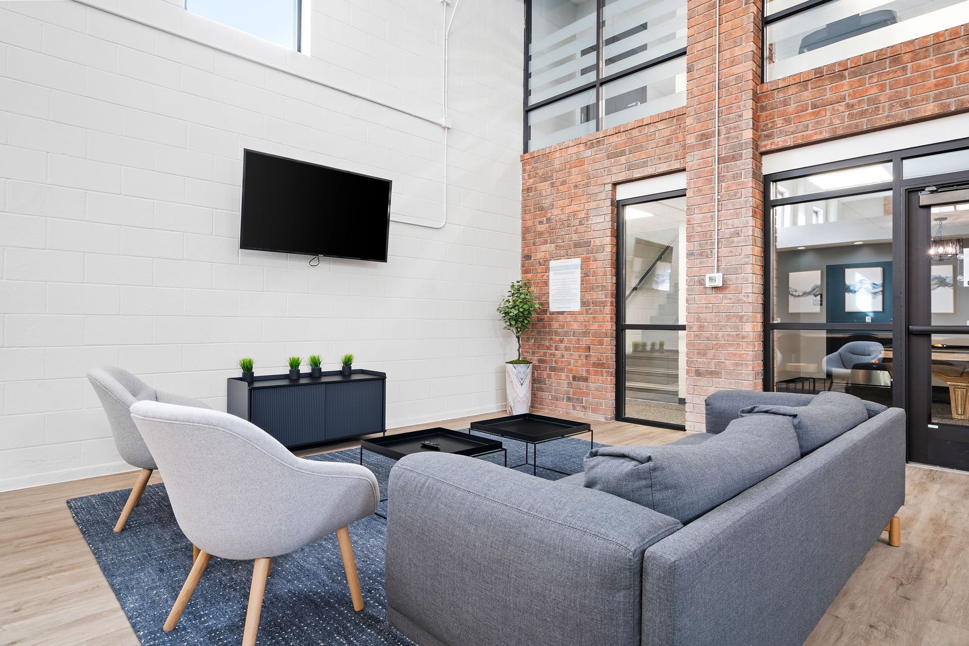 A living room with a couch , chairs and a flat screen tv.
