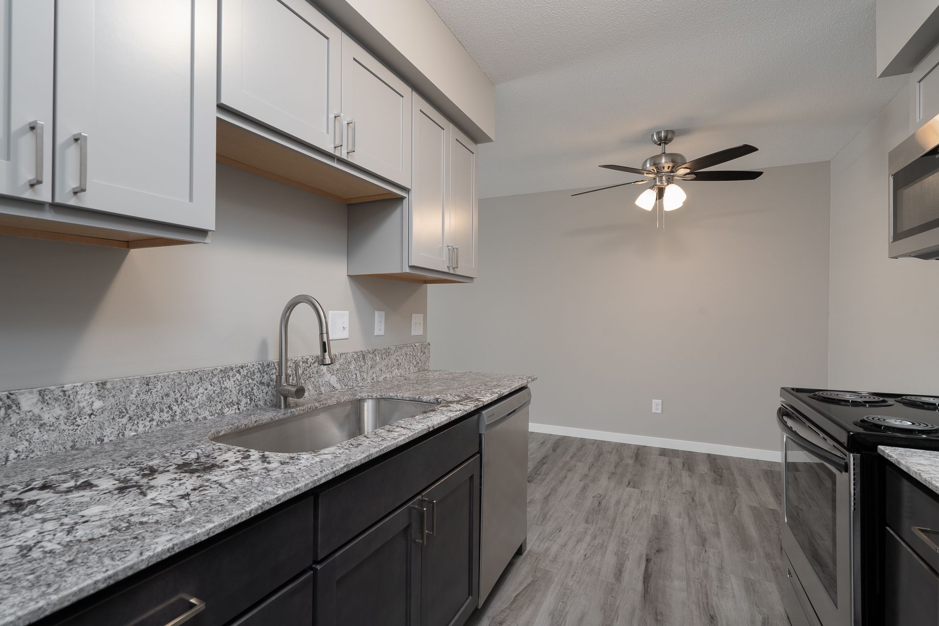 A kitchen with granite counter tops and a ceiling fan