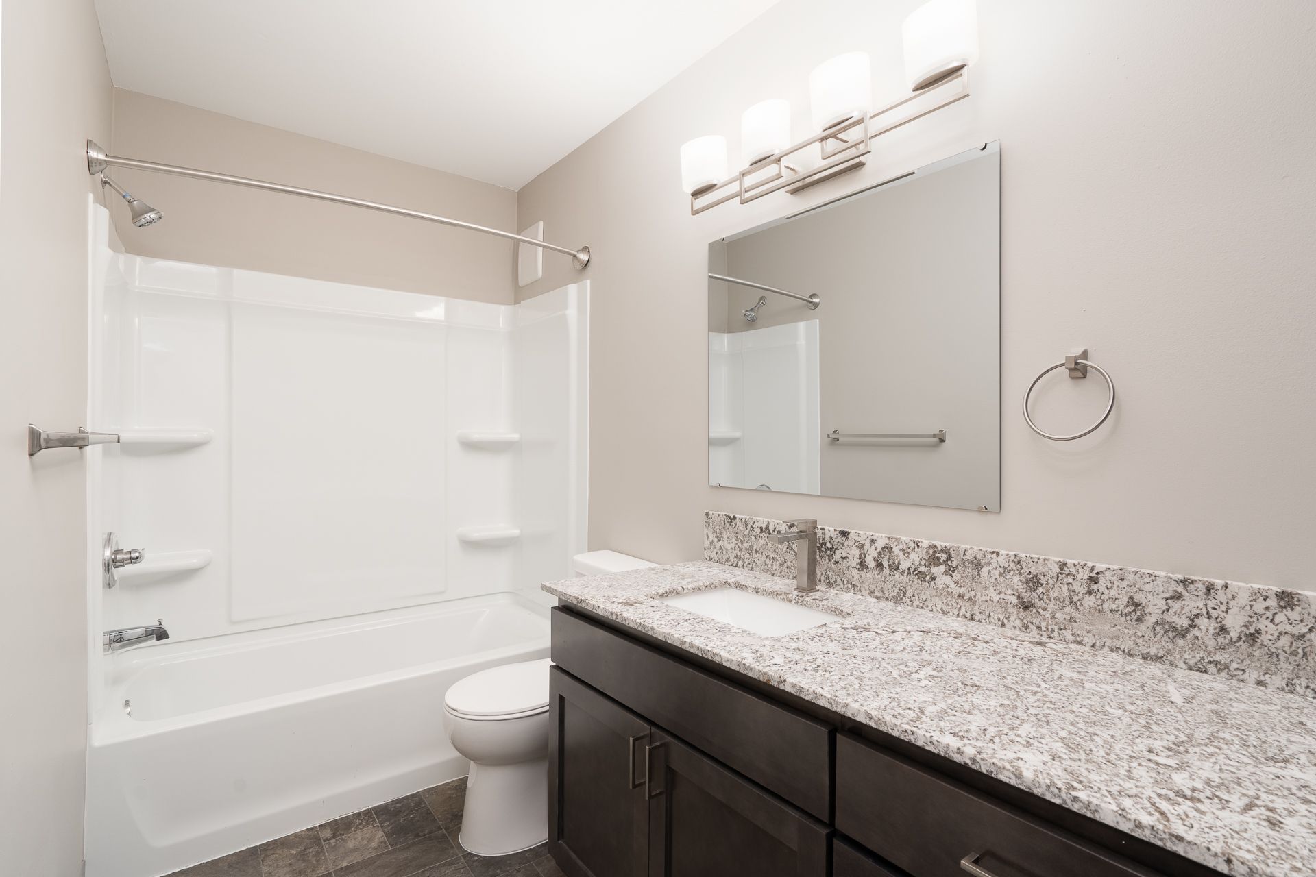 A bathroom with a sink , toilet , bathtub and mirror.