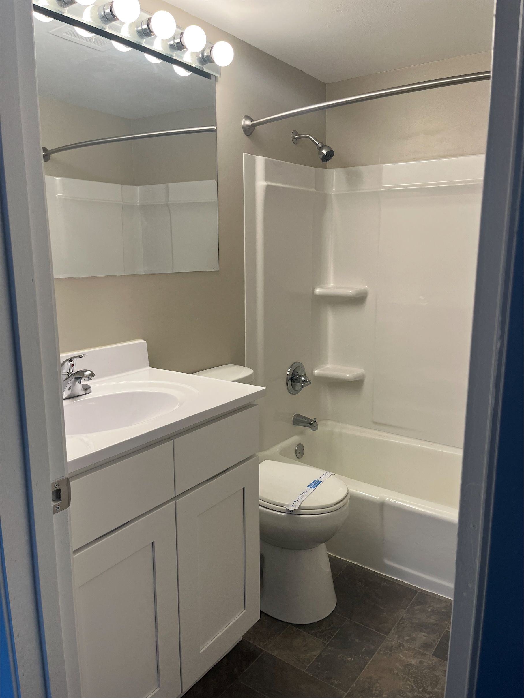 A bathroom with a toilet , sink , and bathtub.