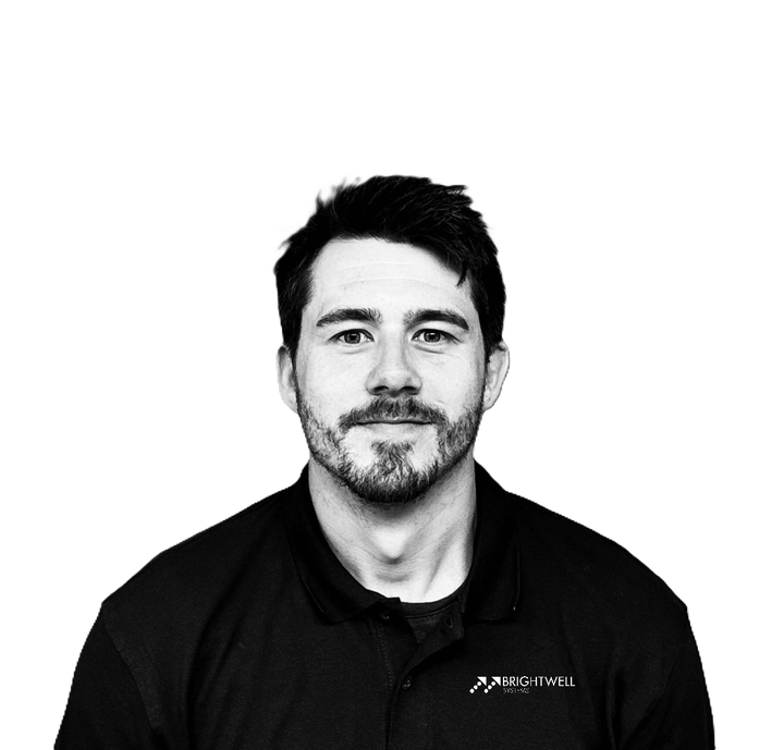 Man with dark hair and a beard, wearing a dark polo shirt, looking at the camera.