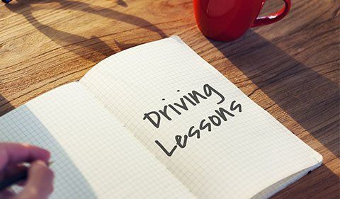 A Person Is Writing In A Notebook About Driving Lessons — ABC Driving School Central Coast In Umina Beach, NSW