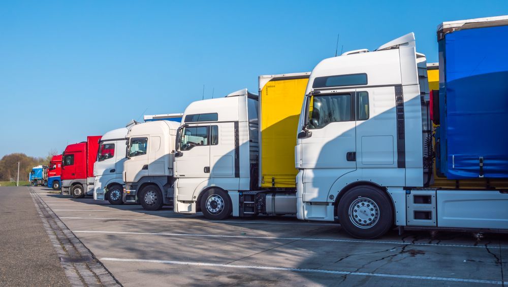 A Row Of Semi Trucks Parked In A Parking Lot — ABC Driving School Central Coast In Umina Beach, NSW