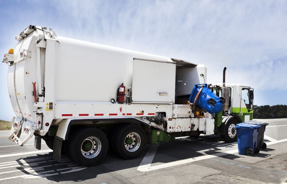 A Garbage Truck Is Tipping Rubbish Into The Truck— ABC Driving School Central Coast In Umina Beach, NSW