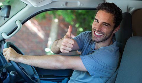 A Man Is Sitting In The Driver 's Seat Of A Car And Giving A Thumbs Up — ABC Driving School Central Coast In Umina Beach, NSW