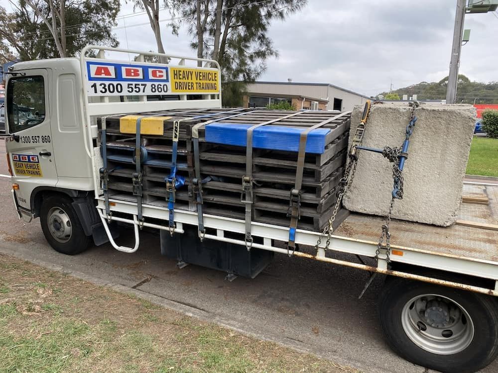 A White Truck Is Loaded With Pallets And Concrete Blocks — ABC Driving School Central Coast In Umina Beach, NSW