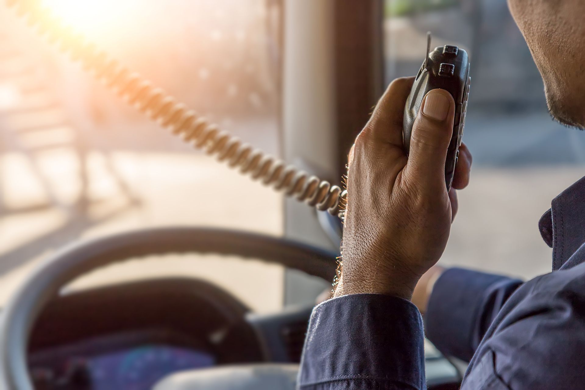 A Man Is Talking Into A Radio While Driving — ABC Driving School Central Coast In Umina Beach, NSW