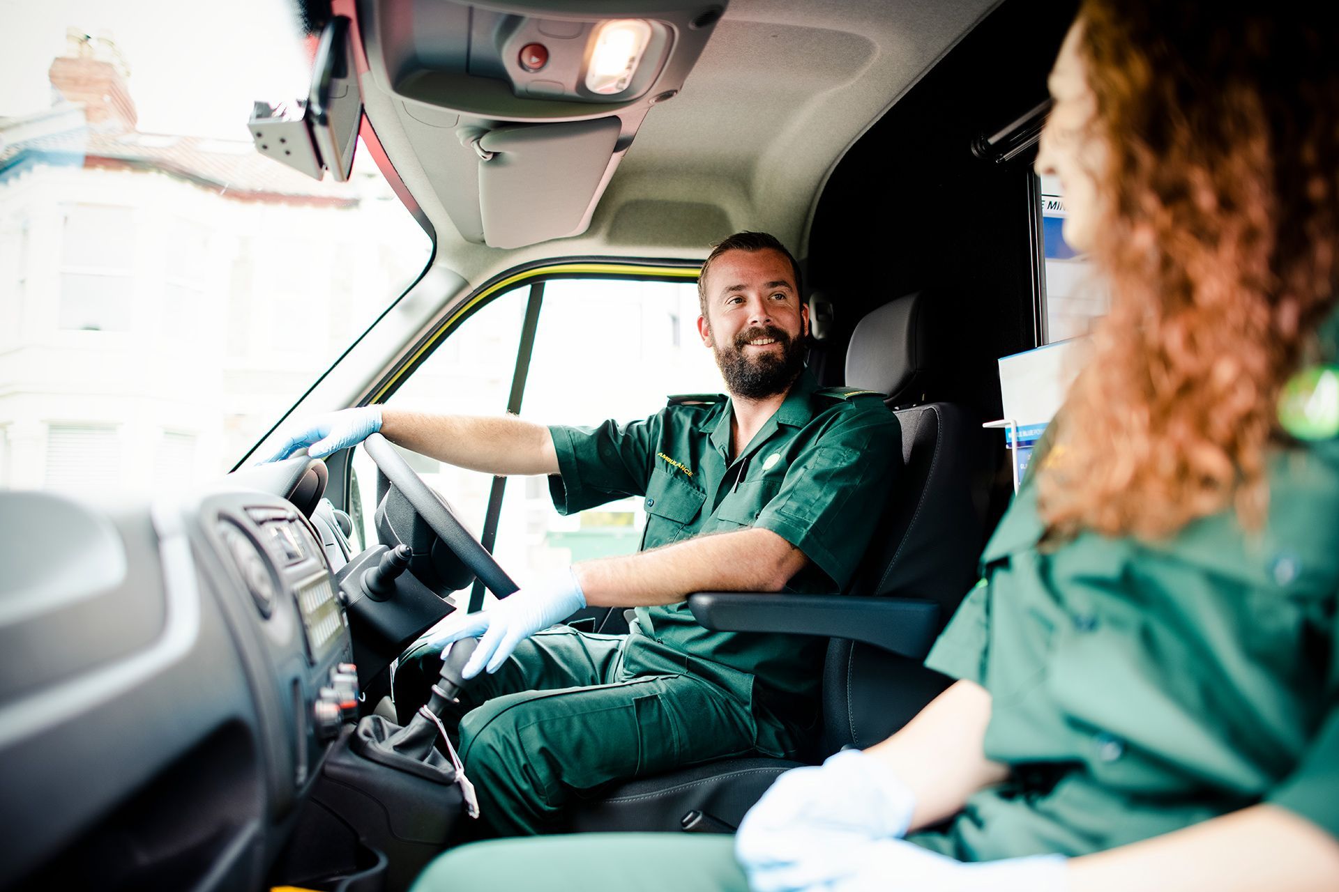 Two People Driving In A Green Ambulance Uniform — ABC Driving School Central Coast In Umina Beach, NSW