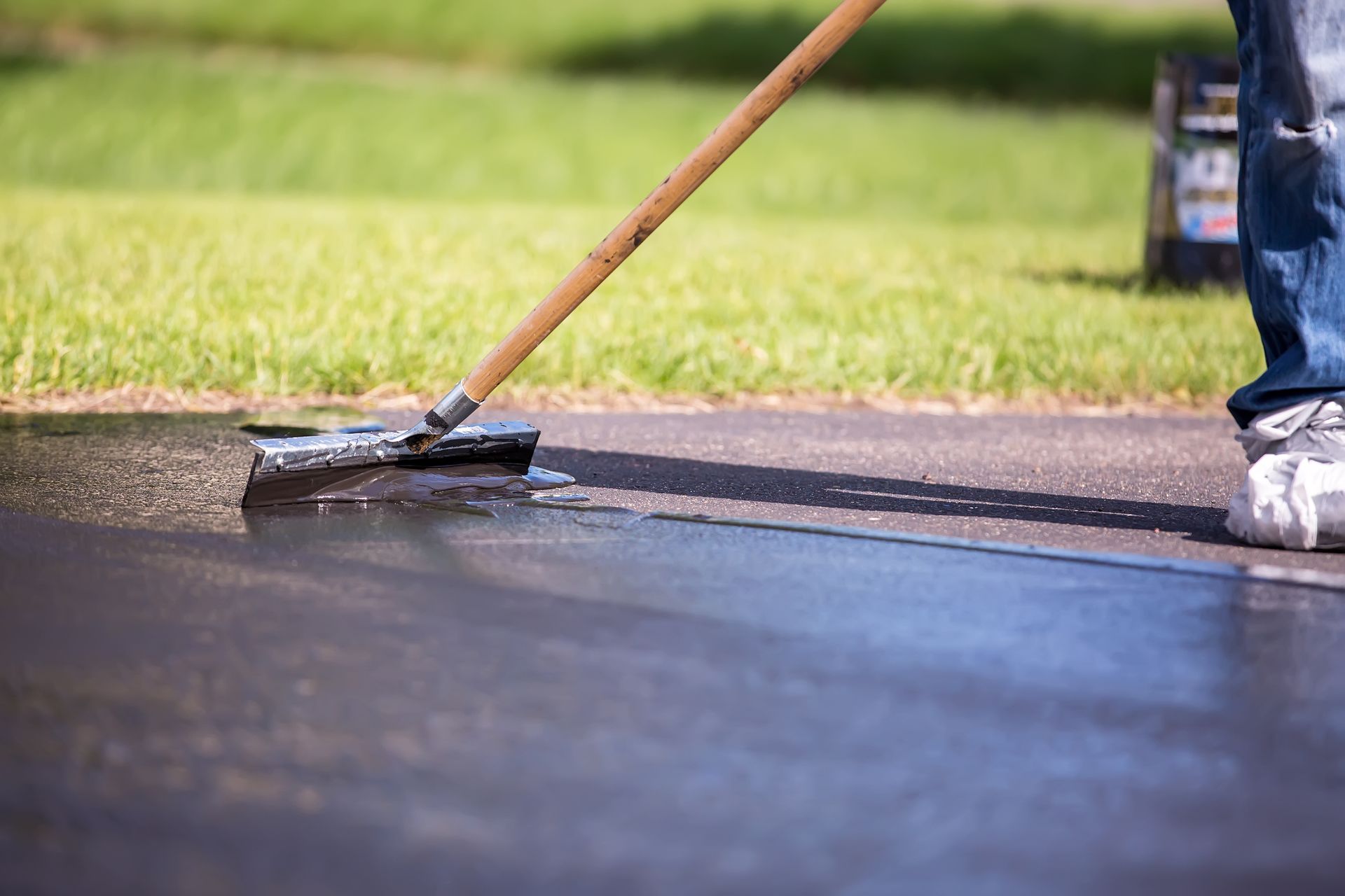 Asphalt sealcoating being applied with a squeegee on a driveway by Allied Paving Co Inc in Toledo, O