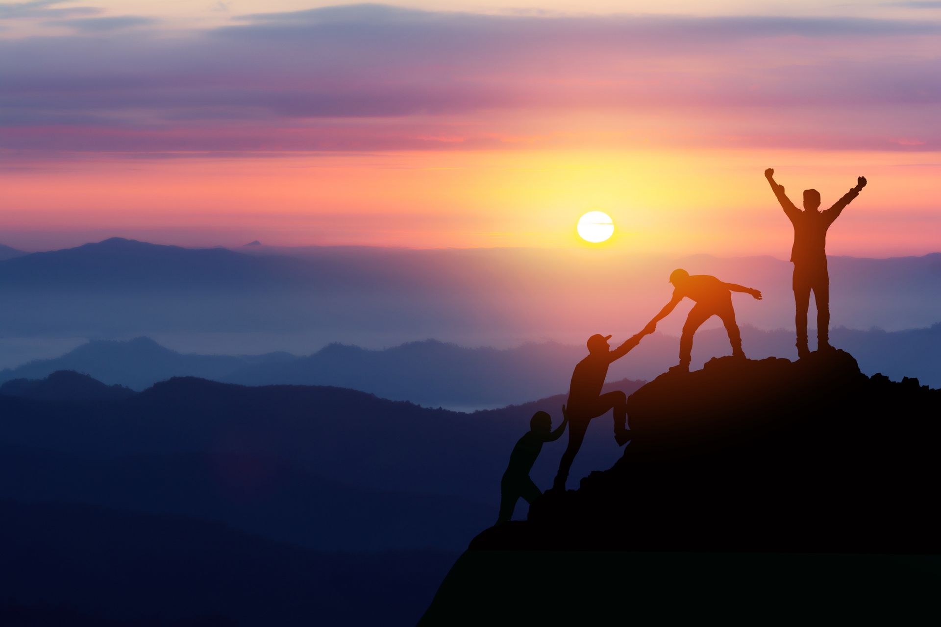 A group of people are standing on top of a mountain.