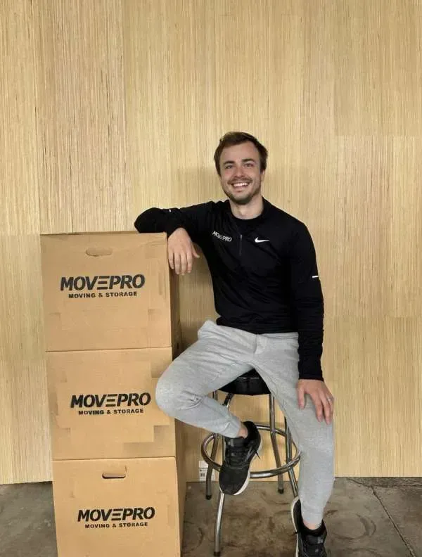 MovePro mover holding packed box ready for residential moving services in Fort Wayne