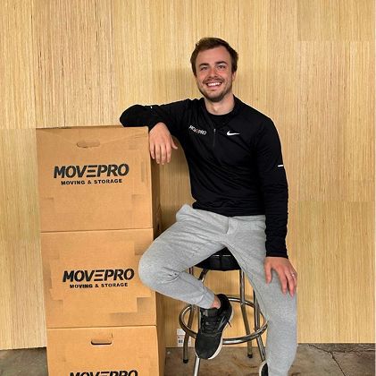 Friendly MovePro mover holding packed box ready for residential move in Northeast Indiana