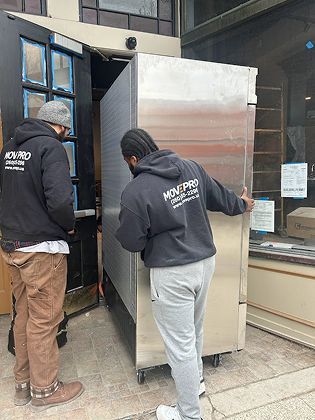 MovePro movers carefully loading furniture into a truck for safe transport