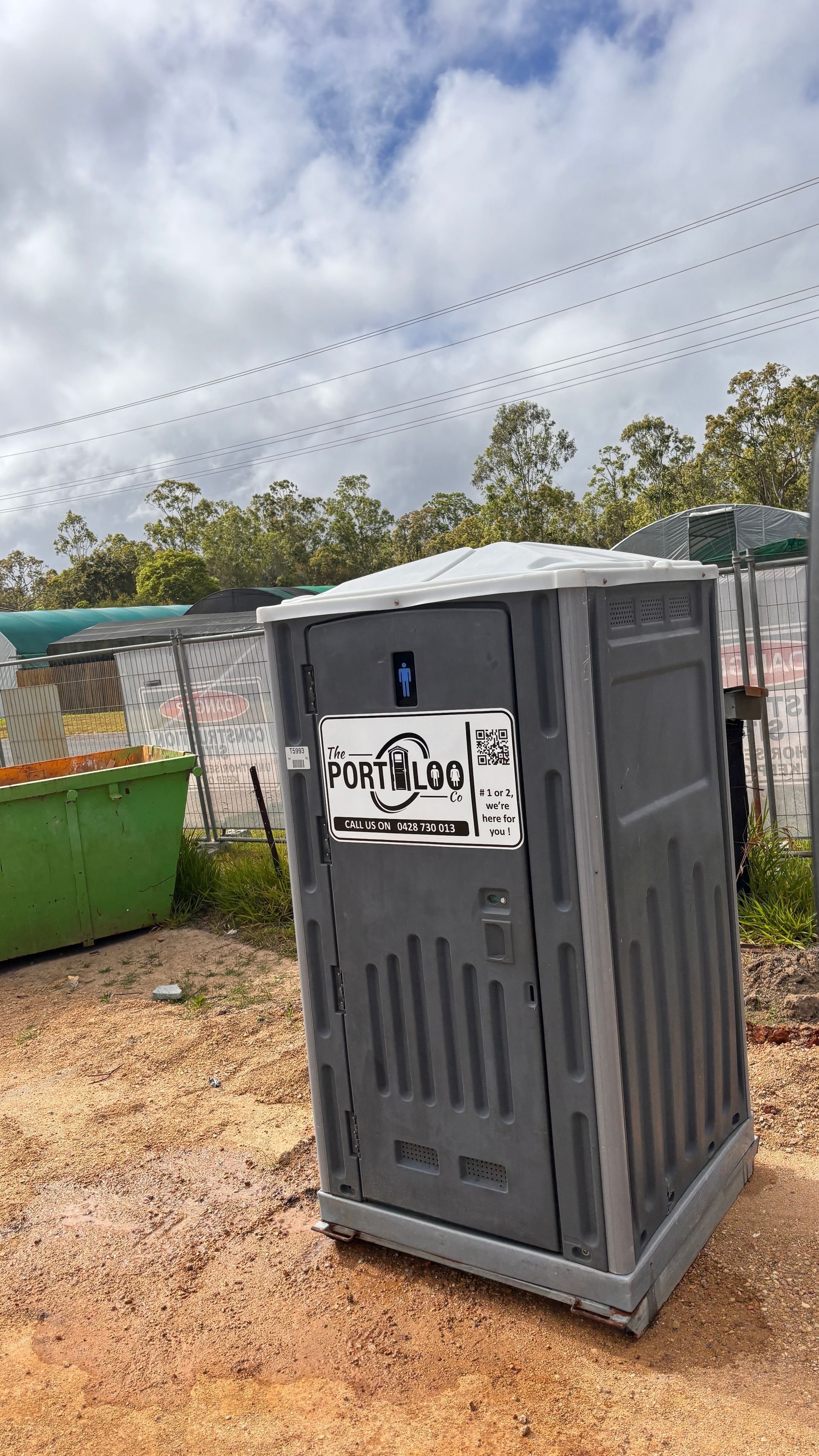 A Portable Toilet Is Sitting In The Middle Of A Grassy Field — The Portaloo Co in Mareeba, QLD