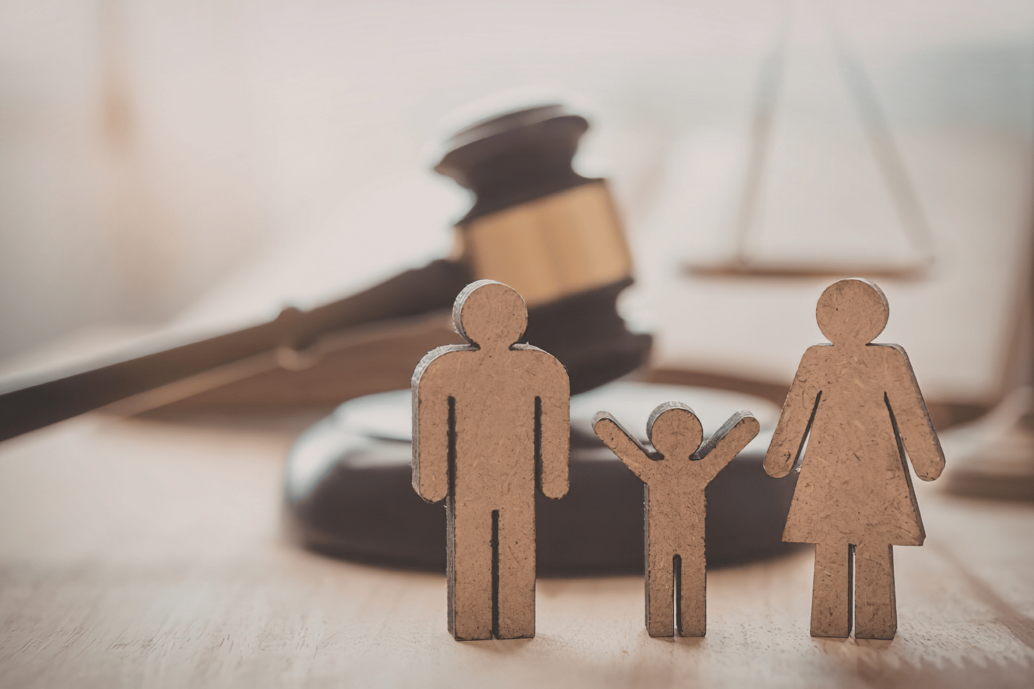 Court gavel behind a small family figurine set on a table